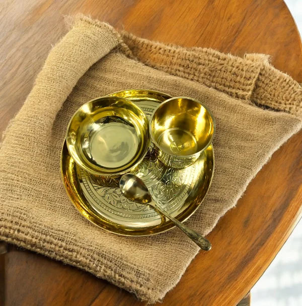 GAUWAL খাঁটি পিতলের বেবি ফিডিং সেট – প্লেট, বাটি, গ্লাস ও চামচসহ পাটের কাপড়ের ওপর রাখা GAUWAL ঐতিহ্যবাহী পিতলের বেবি সেট শিশুদের খাবারের জন্য GAUWAL খোদাই করা পিতলের বেবি খাবারের সেট কাঠের টেবিলের ওপর সাজানো GAUWAL পিতলের বেবি মিল সেট GAUWAL brass baby feeding set with plate, bowl, cup and spoon Handcrafted GAUWAL traditional brass baby food set GAUWAL brass baby plate bowl spoon set on jute cloth GAUWAL premium brass baby feeding set on wooden table GAUWAL brass baby feeding set GAUWAL baby brass food set